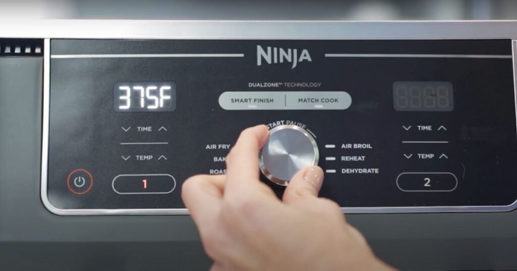 Ninja DZ401 Air Fryer Review: A Powerful Upgrade or Overhyped? 2 Close-up of Ninja DZ401 digital control panel with hand adjusting temperature knob